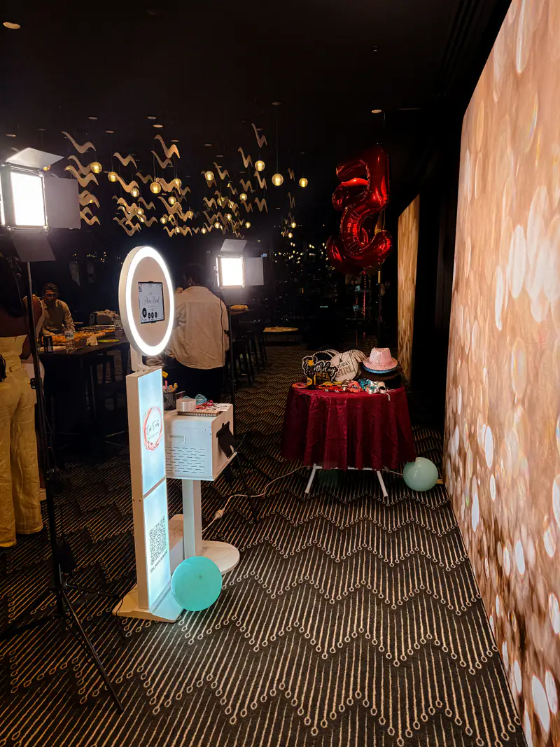 The booth lit up at an evening venue beside a gold bokeh backdrop