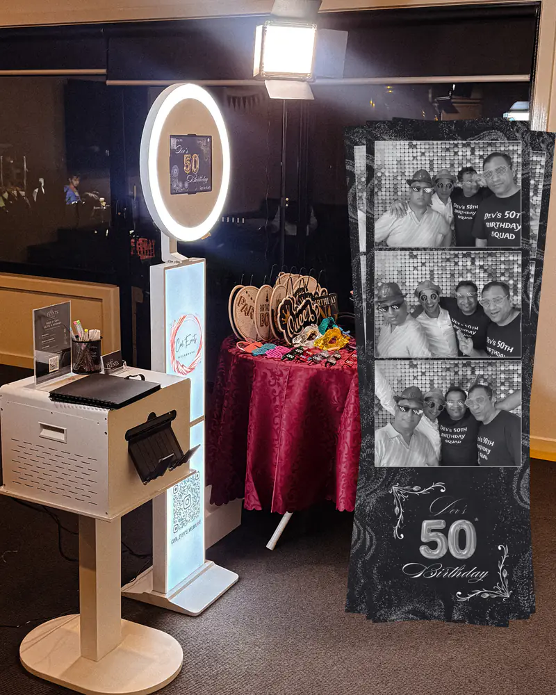 The booth with its printer beside a printed photo strip from a 50th birthday