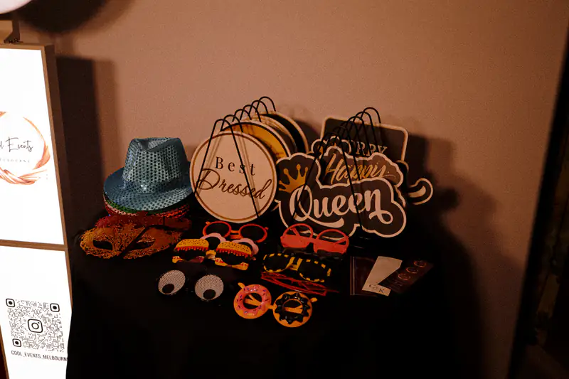 A props table with hats, glasses and signs beside the booth