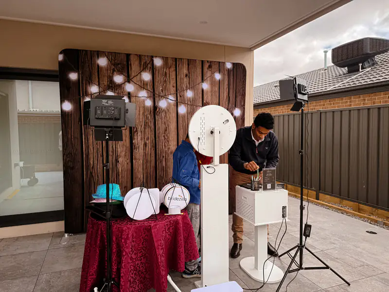 Setting up the booth in front of the rustic wood backdrop outdoors